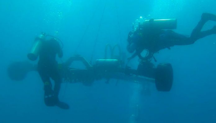 Experts working underwater to lay optical fibre cable on the seafloor