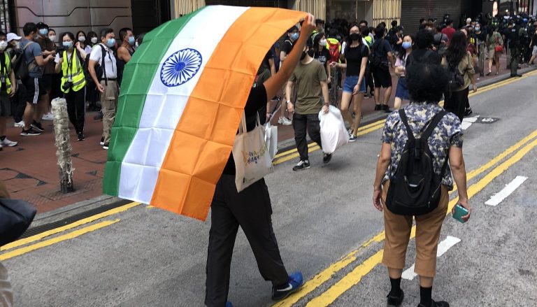 Hong Kong pro-democracy protester carries Indian flag during Chinese National Day protests because India is fighting China