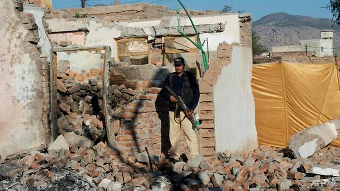 A policeman stands guard outside the Hindu temple destroyed by a Muslim mob in Pakistan