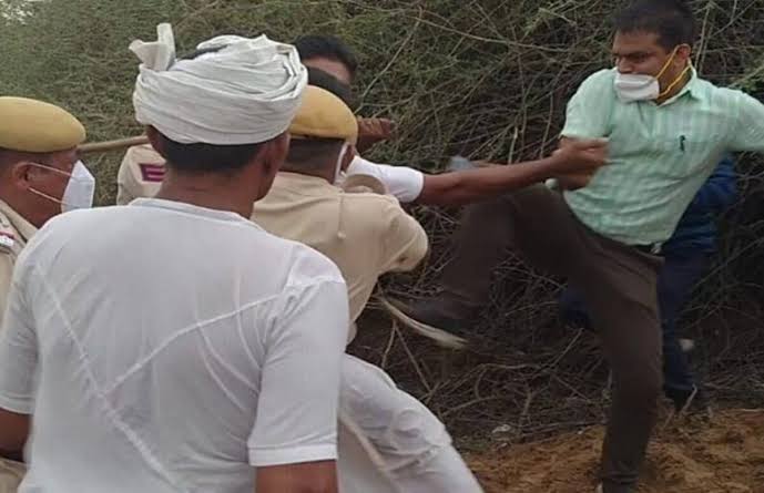SDM Bhupendra Yadav seen ki king a farmer in a protest in Jalore