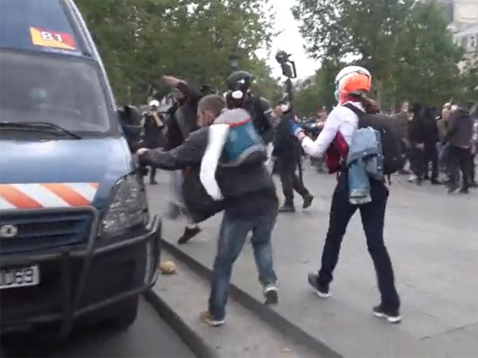 Protester breaking Police vehicle