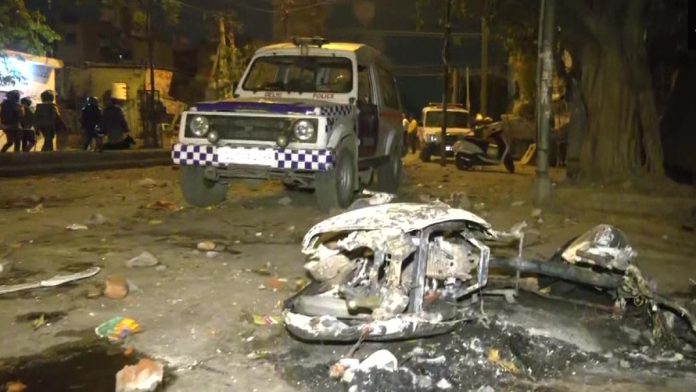 Charred remains of a torched vehicle lying on a road in Delhi's Jahangirpuri