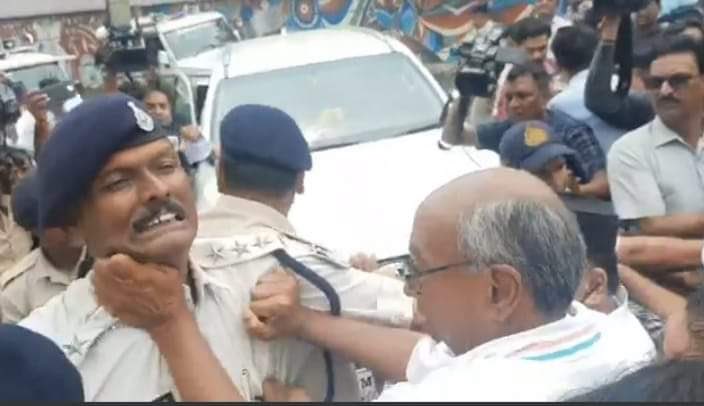 Congress leader Digvijaya Singh grabs a cop by his collar, assaults him