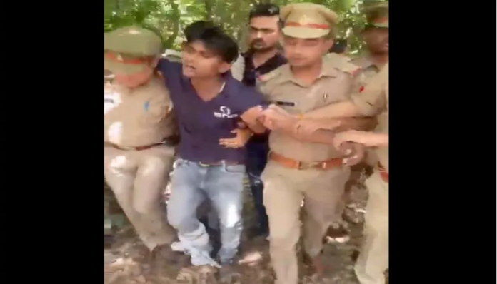 The accused held by the police.