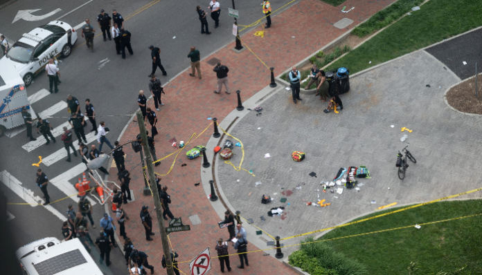 Police officers conduct an investigation at the shooting scene.