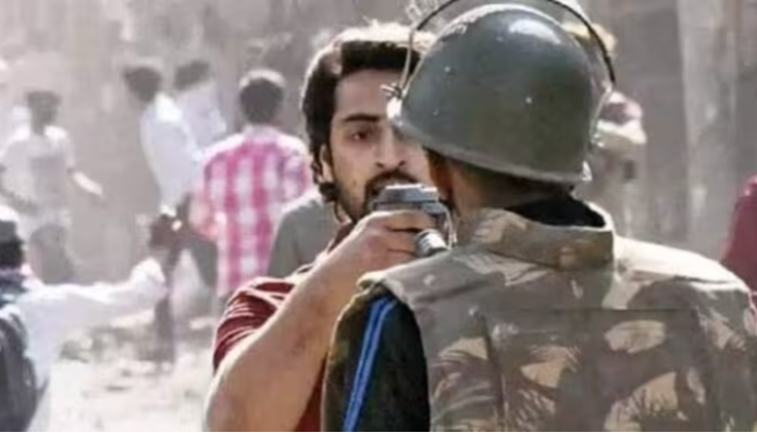 Shahrukh Pathan pointing a gun at a policeman.