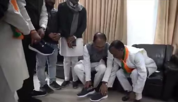 Madhya Pradesh: Former CM Shivraj Singh Chouhan puts on shoes for a BJP worker who remained barefoot for six years for the BJP’s win